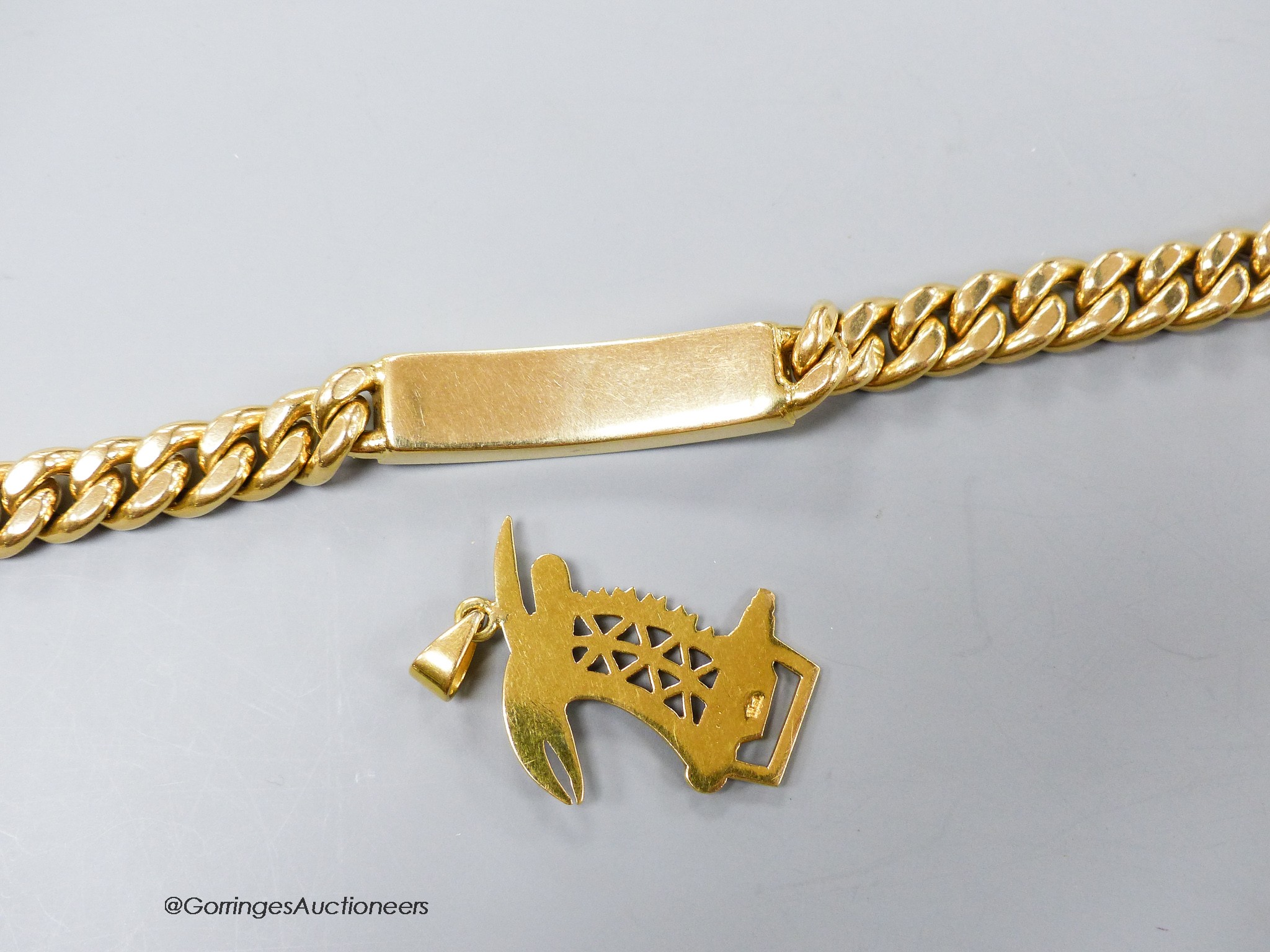 A yellow metal (stamped 750) curb link identity bracelet, 21cm and a 750 and diamond set pendant, 35mm